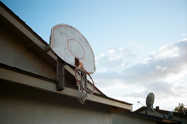 Lage hoek die van een gebroken basketbalmand op de bovenkant van een huis is ontsproten