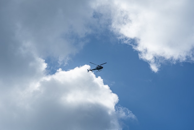 Gratis foto lage hoek die van een helikopter in de bewolkte hemel is ontsproten