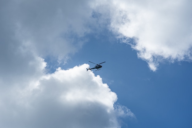 Lage hoek die van een helikopter in de bewolkte hemel is ontsproten
