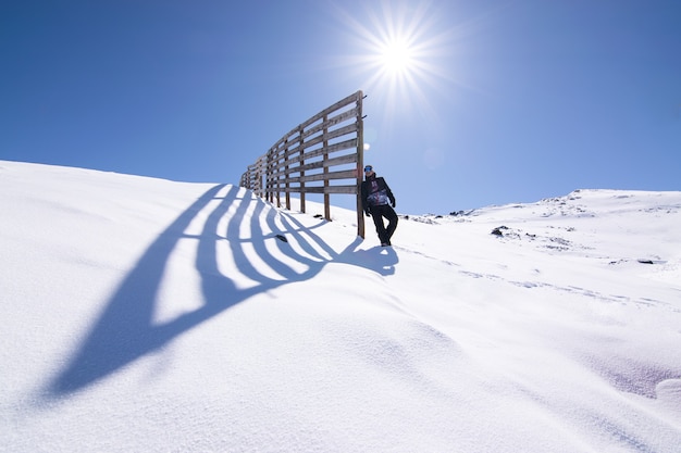 Lage hoek die van een mannetje is ontsproten dat zich op een besneeuwde bergtop onder het zonlicht bevindt