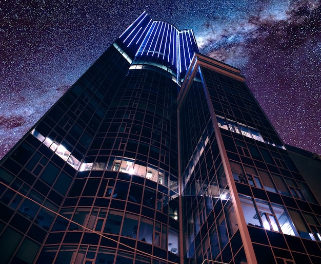 Lage hoek die van een moderne futuristische bedrijfsarchitectuur is ontsproten onder een adembenemende sterrenhemel