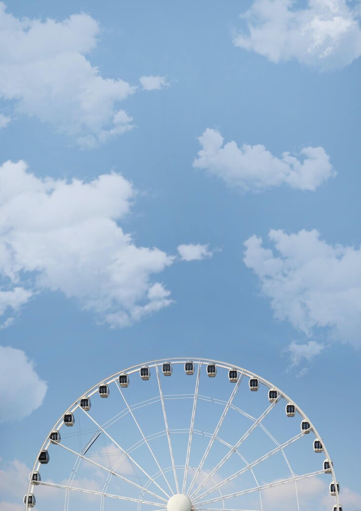 Gratis Foto lage hoek die van een reuzenrad op bewolkte hemel is ontsproten