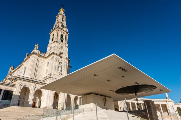 Lage hoek die van het Heiligdom van Onze Lieve Vrouw van Fatima, Portugal onder een blauwe hemel is ontsproten