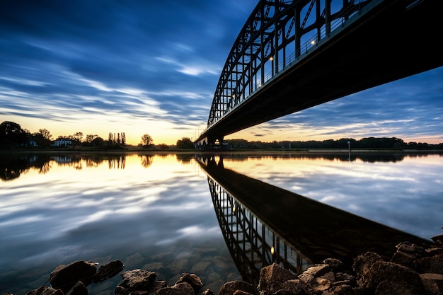 Lage hoek die van Sydney Harbour Bridge in Australië tijdens zonsondergang is ontsproten