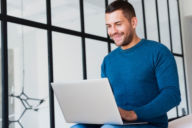 Lage hoek jonge man aan het werk op laptop