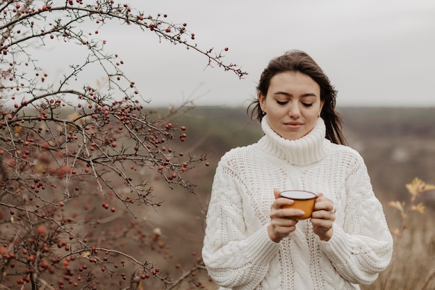 Lage hoek jonge vrouw met thee in mok