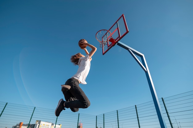 Gratis foto lage hoek man die basketbal speelt