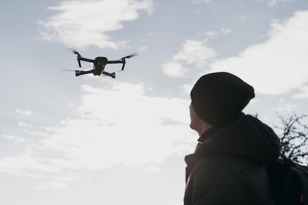 Gratis foto lage hoek man kijken naar drone