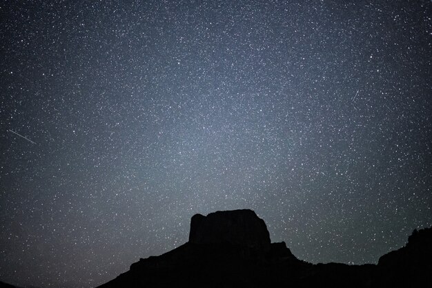 Lage hoek shot van een heuvel onder een prachtige sterrenhemel