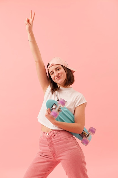 Gratis foto lage hoek smiley meisje met skateboard