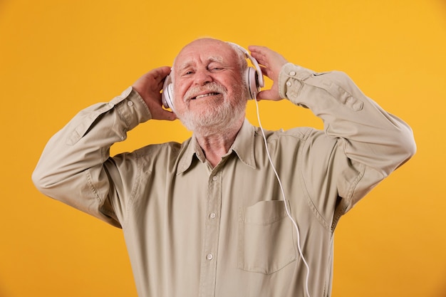 Lage hoek smiley senior luisteren muziek