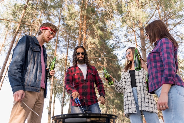 Lage hoek van een groep vrienden die een barbecue met bier hebben