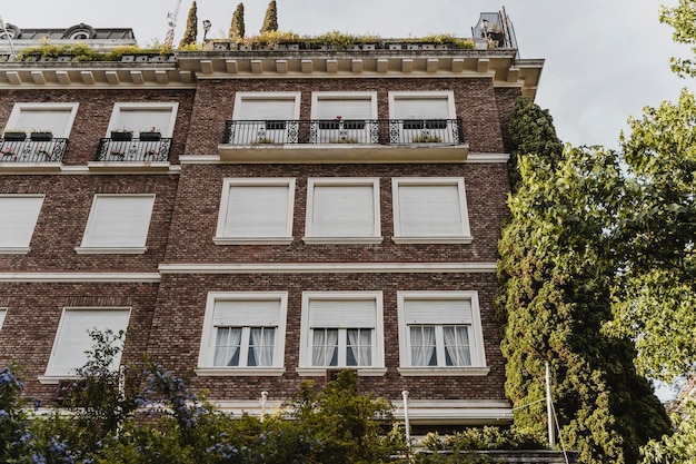 Gratis foto lage hoek van flatgebouw met ramen in de stad