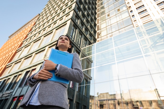 Lage hoek van het klembord van de onderneemsterholding in de stad