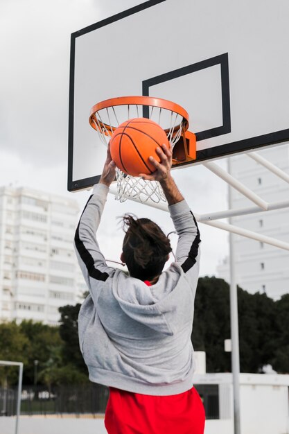 Lage hoek van meisje gooien in basketbal hoepel