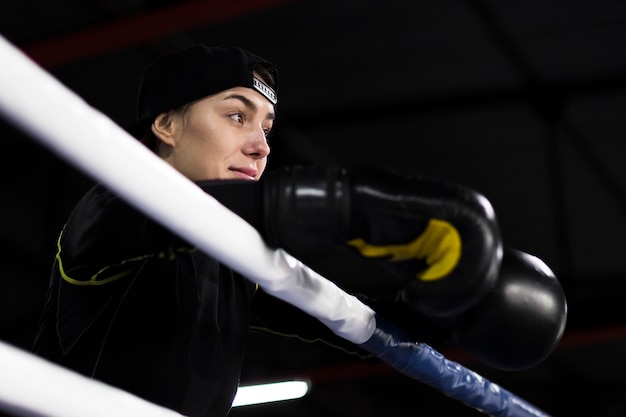 Lage hoek van vrouwelijke bokser poseren in de ring