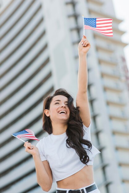 Lage hoek vrouw met twee usa vlaggen en glimlachen