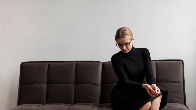 Gratis foto lage hoek vrouw zittend op de bank