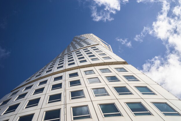 Lage hoekmening van de Turning Torso onder een blauwe lucht en zonlicht in Malmö in Zweden