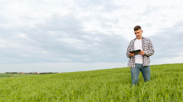 Lage hoekmens met tablet bij landbouwbedrijf