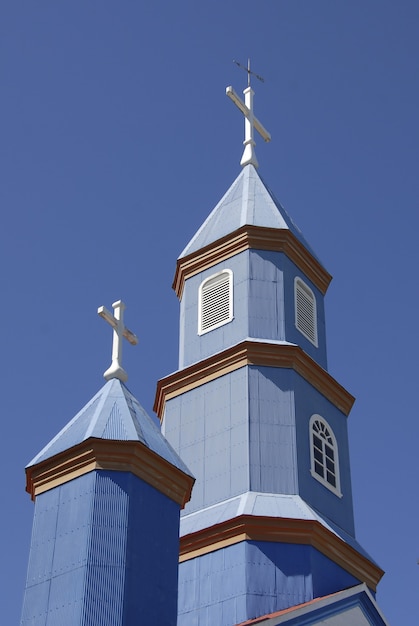 Gratis foto lage hoekopname van een kleine blauwe kerk onder een blauwe en heldere hemel
