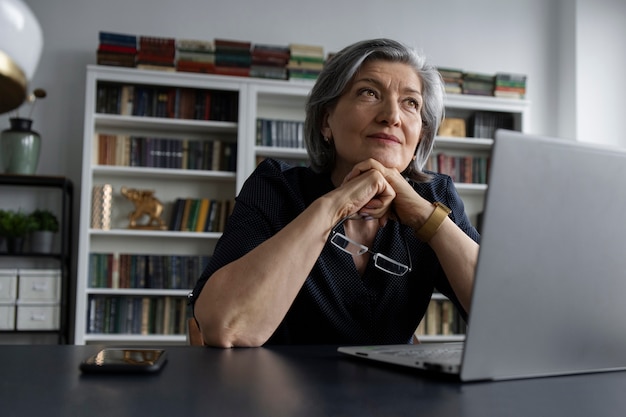 Lage hoekvrouw die aan laptop werkt