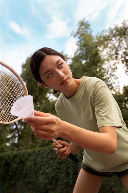 Gratis foto lage hoekvrouw die badminton speelt