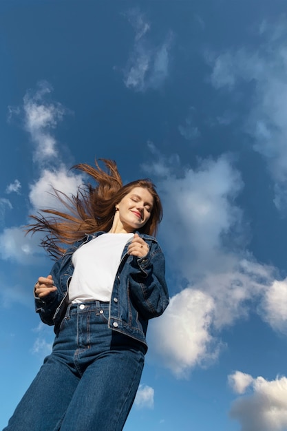 Gratis foto lage hoekvrouw die in openlucht stelt