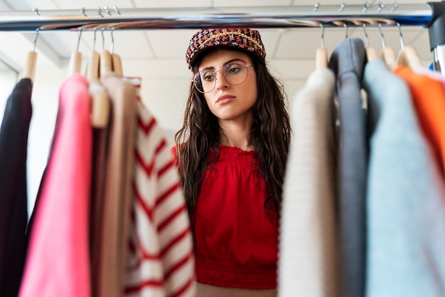 Lage hoekvrouw die kleren bekijkt