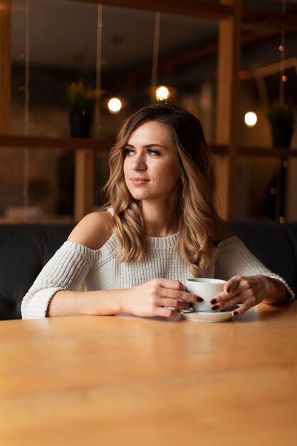 Lage hoekvrouw het drinken kop van koffie