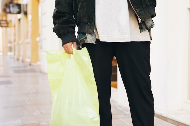 Lage sectie van een man die plastic tas in de hand