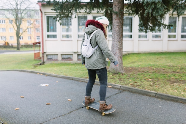 Lage sectie van vrouw die op skateboard bij straat schaatsen