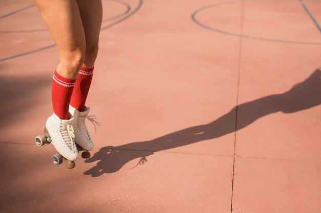 Gratis foto lage sectie van vrouwelijke skater die in lucht op hof springt