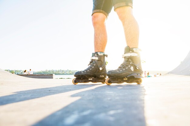 Lage sectieweergave van een mens die in vleetpark rollerskating tijdens de zomer