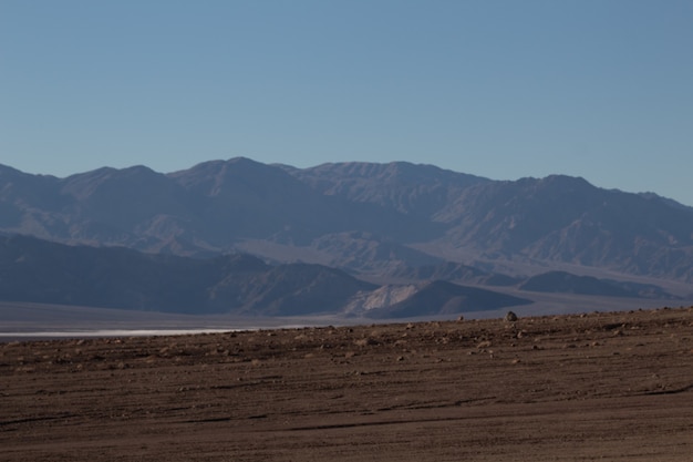 Gratis foto landschap dat van een semi-aride, verlaten gebied is ontsproten aan de voorkant van een prachtige bergketen