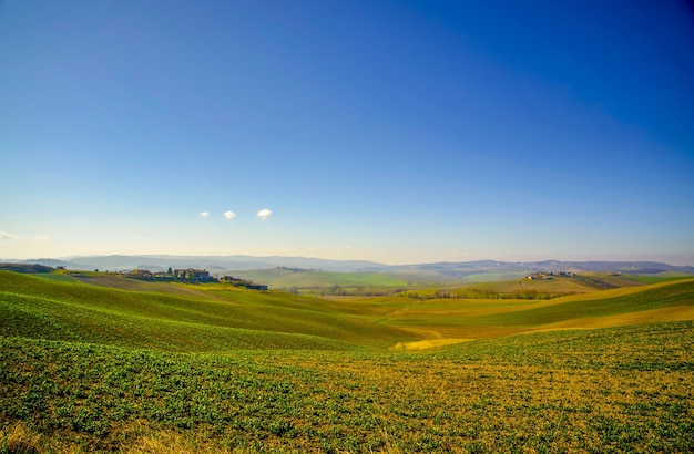Landschap opname van een heldergroen veld en een heldere blauwe lucht