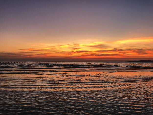 Landschap van zonsondergang op het strand met kalmerende golven van de oceaan