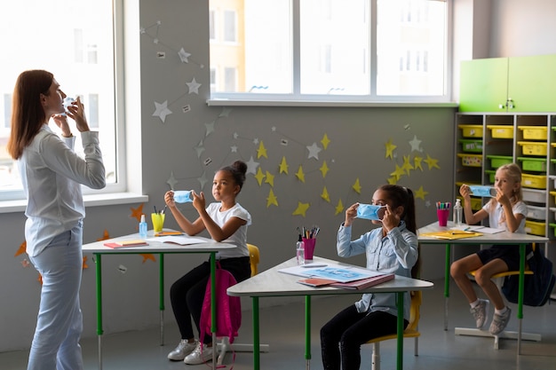 Lang geschoten kinderen die leren hoe ze een medisch masker moeten gebruiken