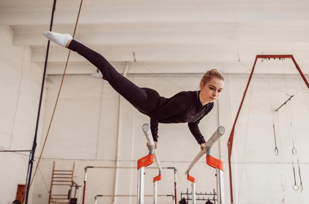 Lang geschoten vrouw training voor gymnastiekkampioenschap