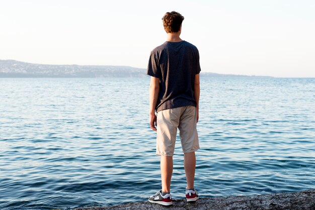 Lang schot van jongen die op zee ontspannen