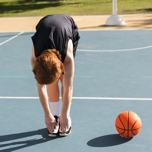 Lang schot van jongen met basketbalbal