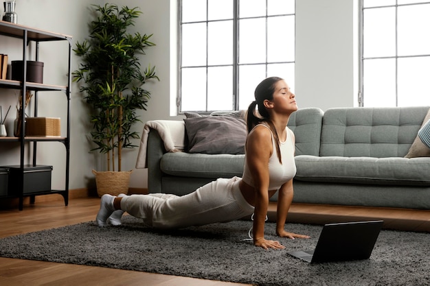 Lang schot van vrouw die yoga beoefent