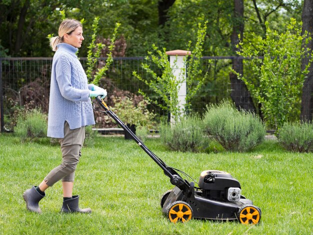 Lang shot vrouw maaien van de tuin