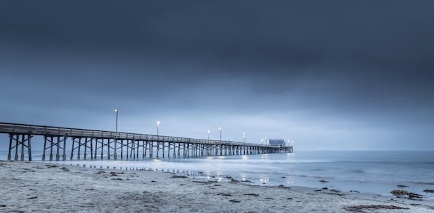 Lange blootstelling van een houten pier in de zee in Californië in de avond