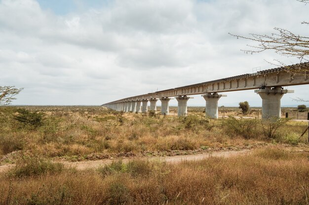 Lange brug over een woestijn onder de bewolkte hemel gevangen in Nairobi, Kenia