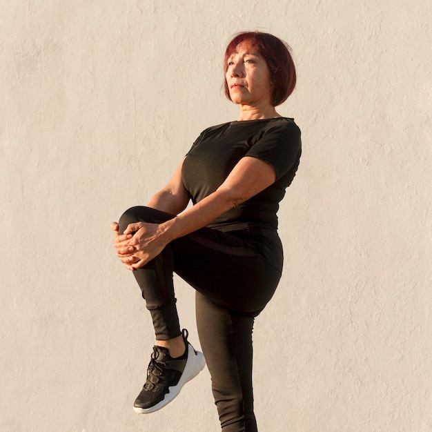 Gratis foto lange meningsvrouw die haar benen uitrekken