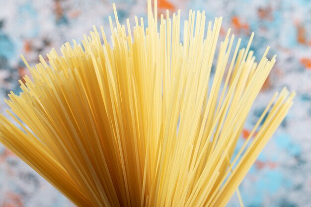Lange rauwe spaghetti op kleurrijk.