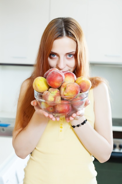 Langharig meisje in geelhoudende perziken