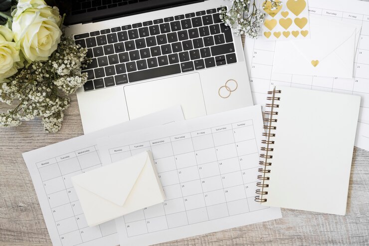 Gratis Foto laptop; bloemen; envelop; kalender en spiraalvormig notitieboekje op houten bureau