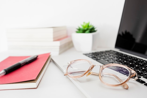 laptop; bril; pen en dagboek op het bureau